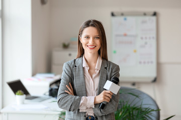 Female journalist with microphone in office