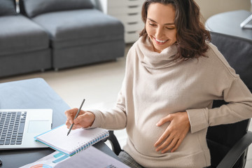 Pregnant businesswoman working in office