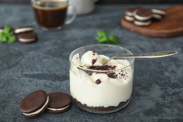 Glass with tasty ice-cream and chocolate cookies on dark background