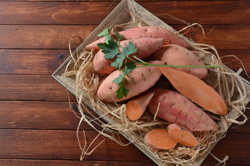 Sweet potatoes on wooden background. Healthy vegan food concept