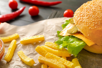 Tasty doner kebab in bun and french fries on table, closeup