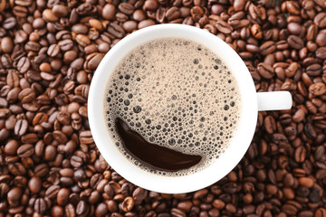 Cup of hot coffee on beans