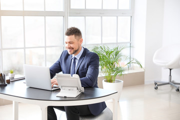 Businessman sitting on fitness ball while working in office - Powered by Adobe