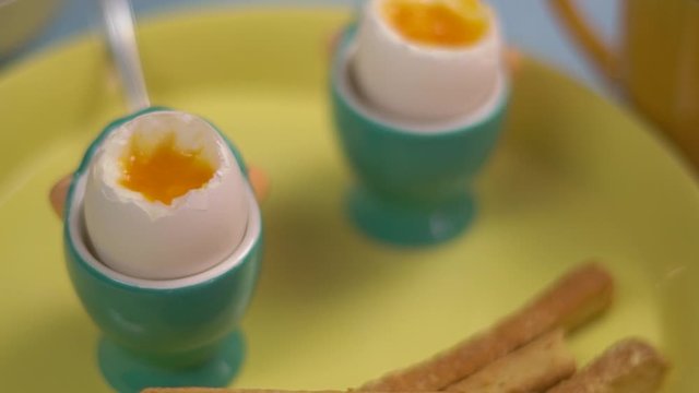 Two coque eggs on a green plate with toast
