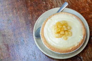 A piece of homemade Pineapple tart on wooden table. Tarts is a baked dish and usually fruit-based, sometimes with custard.