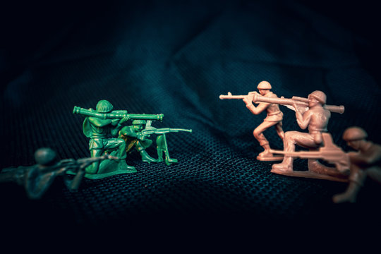 Green and tan plastic army men in firing line