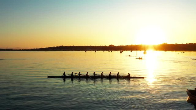 Aerial golden sunset view above Auckland port, rowing boat in forefront