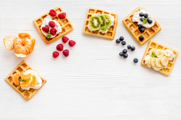 Breakfast with freashly baked belgian waffles on white background top-down frame copy space