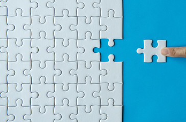 Woman hands putting Jigsaw puzzles,Jigsaw white color,Puzzles pieces grid,Success mosaic solution...