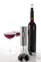Metallic electronic cordless corkscrew. On a white mirror background. Near the aerator. In the background are two glasses and a bottle of wine.