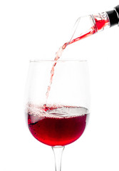 Red wine is poured through aerator into a glass with a thin stream. White background. Isolated. Close-up.