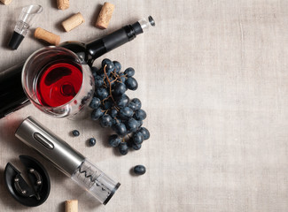 Electric corkscrew in steel gray. On a gray linen background. Near a glass, several corks, a bunch...