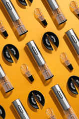 Electric gray metal corkscrew, wine aerator and corkscrew stand. Yellow background .. Top view. Pattern. Hard light and shadow.