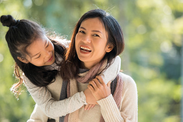 Fototapeta premium happy family on autumn walk. mother and daughter walking in the park and enjoying the beautiful autumn nature..family, children and happy people concept - hugging mother and daughter.