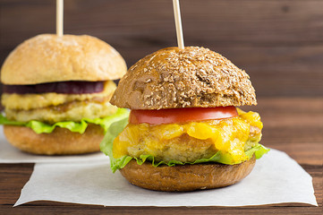 Vegetarian Burger with vegetable cutlet, pumpkin sauce, tomato on a dark wooden background. The concept of vegan, vegetarian, healthy food.