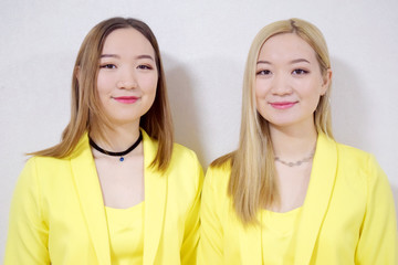 happy beautiful asian twin sisters