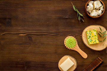 Hair care concept. Coconut oil, brush on dark wooden background top-down frame copy space