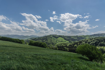 Fototapeta na wymiar schoene gruene berglandschaft mit wolken am himmel