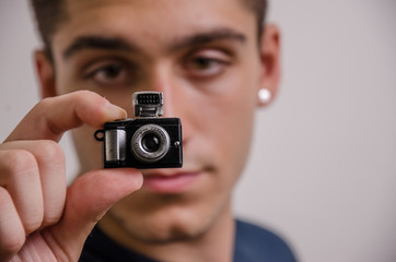 Young man with a miniature camera