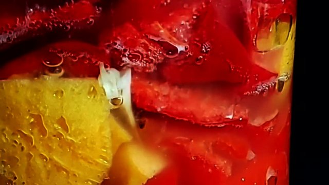 Chiles picantes y frutas fermentando en botella vidrio