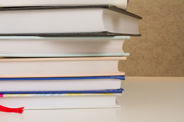 a stack of books and glasses on a white table. the concept of learning, reading, library, University. space for text.