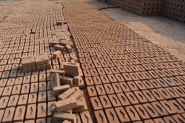 Raw brick laid out in stacks for drying. Bricks in a brick factory. Traditional production of clay...