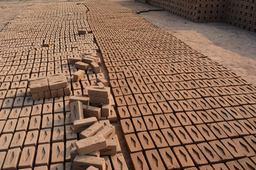 Raw brick laid out in stacks for drying. Bricks in a brick factory. Traditional production of clay bricks in India.