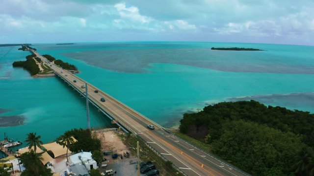 Aerial 4K UHD drone footage of the famous Highway One leading from Miami Beach all the way down to Key West in Florida. The turquoise Atlantic Ocean water is surrounding the coral reef islands.