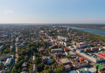 Aerial view of Tomsk city with a lot of trees and Tom river. Summer, sunny day.