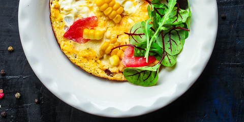 omelette scrambled vegetables and salad, healthy snack (corn, tomato, onion and other ingredients) menu concept background. top view. copy space