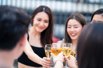 Group of young gang best friends boy and girls having party at rooftop restaurant. Girls drinking wine alcohol and toasting glass feeling happy enjoy, fun with smile face. Night lifestyle concept.