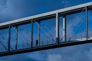 Bridge City Man Crossing infront of blue sky