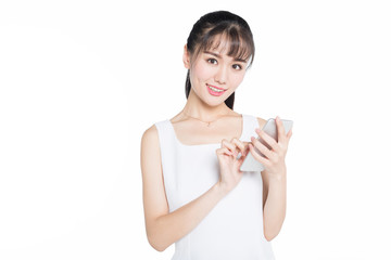 young woman wearing white dress using smartphone against white background