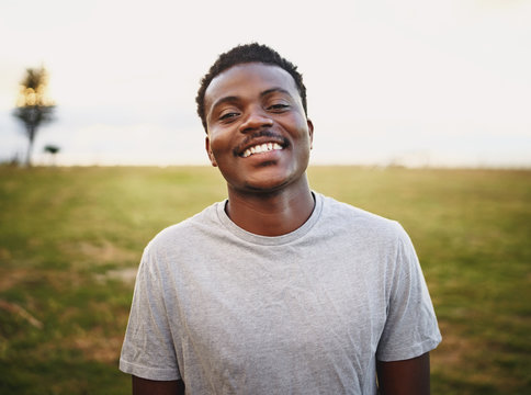 Happy young male athlete smiling and looking at camera at park