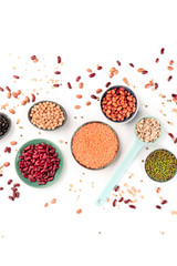 Obraz na płótnie Canvas Legumes, overhead shot on a white background. Vibrant pulses including red beans, lentils, chickpeas, soybeans and black-eyed peas, a flat lay composition
