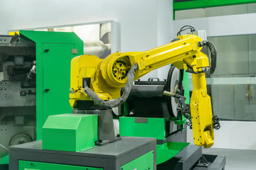 robotic arm handling the metal machined shaft parts polishing between the production line....