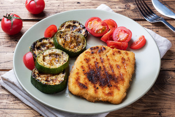 Schnitzel of chicken and zucchini cooked on the grill. Fresh tomatoes on a plate. Ready delicious...