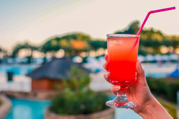 Woman with refreshing cocktail near swimming pool outdoors, closeup. Space for text