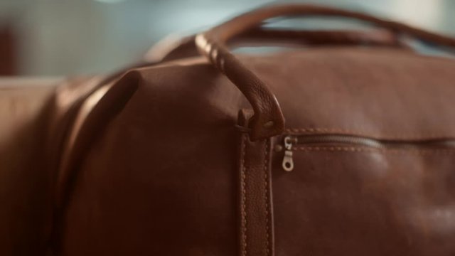 Close up sliding detail on handmade leather tote bag with side zipper