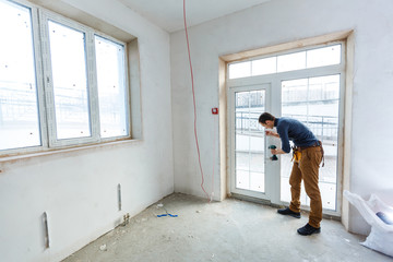Construction worker installing window in house