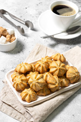 Lemon cookies with poppy seeds in a white ceramic plate on the gray kitchen table. Shortbread. Space for text