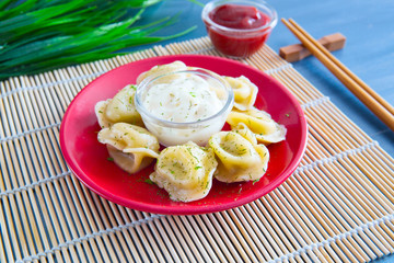 Delicious dumplings in the pot on the table Fresh boiled dumplings with hot steams on a plate