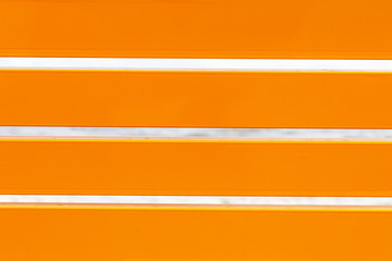 orange horizontal wooden boards, back of a garden bench, close-up background