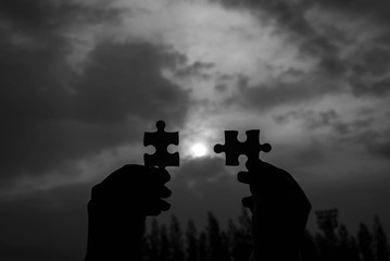 Hand women connect couple puzzle piece together with sunlight background,Business success and...