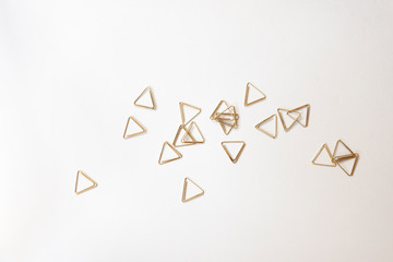 金色のワイヤークリップ　針金　幾何学　白背景　余白　コピースペース　文字スペース