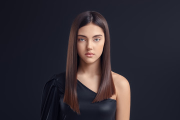 Young woman with beautiful straight hair on dark background