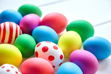 Easter eggs. Many colorful chicken eggs on white wooden background