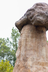 Stonehenge like structure in a zen theme garden with a giant rock placed on top of a vertical...