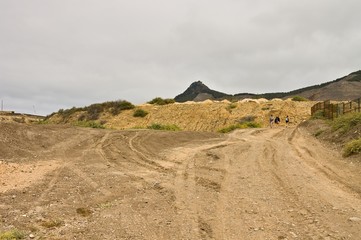 A trekking path into a desertic place with a volcano in the background (Porto Santo, Portugal, Europe)