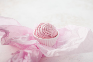 Homemade pink berry meringue on paper.